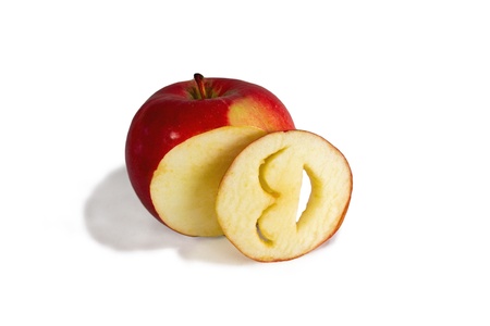 bright red apple and cut into a laughing smiley face carved from a piece of appleの写真素材