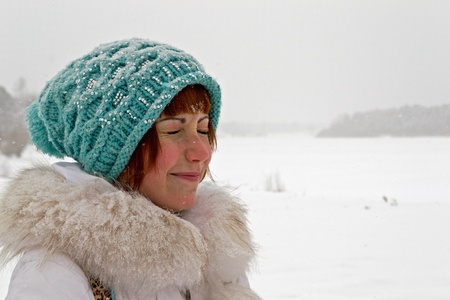 girl in winter clothes blinked snow fromの写真素材