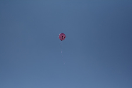 the balloon flying in the distance with a cheerful smileの写真素材