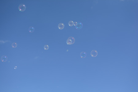 a lot of colorful soap bubbles on blue sky backgroundの写真素材