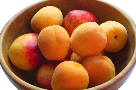 ripe juicy peaches in a deep plate made of bambooの写真素材