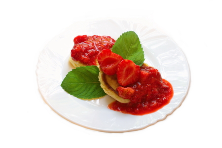 pancakes with strawberry jam with whole berries with mintの写真素材