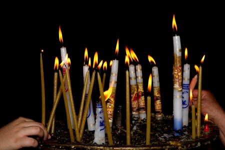 people light candles in the Church of the Nativity in Bethlehemの写真素材