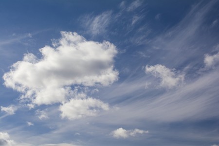 fluffy white cumulus clouds against the blue calm skyの写真素材