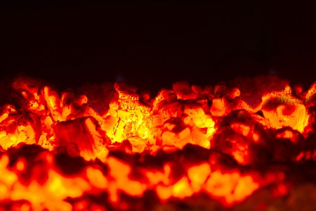 bright burning coals close-up on dark backgroundの写真素材