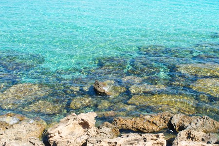 clear turquoise water and rocky sea shoreの写真素材