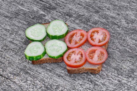 big sandwiches with tomato and cucumber on a colorful backgroundの写真素材