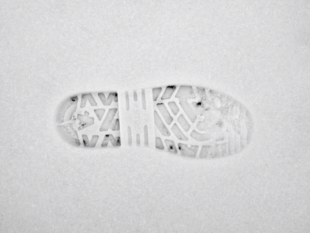 Hiking in winter and fingerprint traces of shoes in the snow layer.
