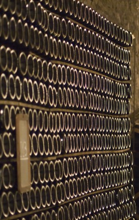 Closeup of bottles of wine aging in an old cellar