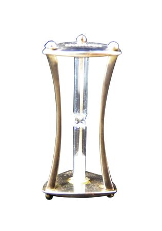 A metal hourglass with white sands over white backgroundの写真素材