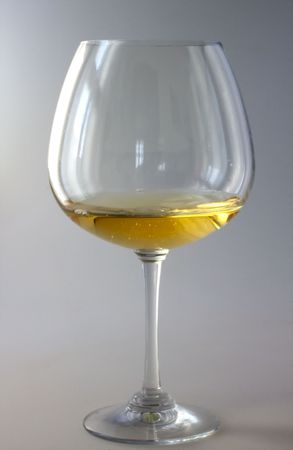 A lonely glass of white wine over gray backgroundの写真素材