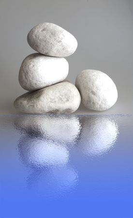 Four big white stones over gray background with reflectionの写真素材