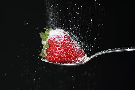 Strawberry on a spoon with sugar fallin' onの写真素材