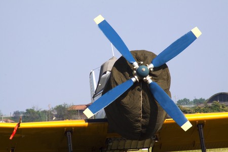 Closeup of front of an old blue and yellow little airplane