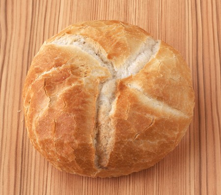 A round piece of bread over wooden background