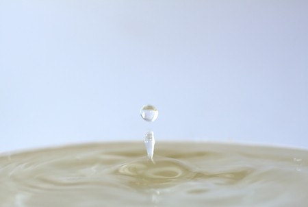Lonely drop coming out from a can full of waterの写真素材