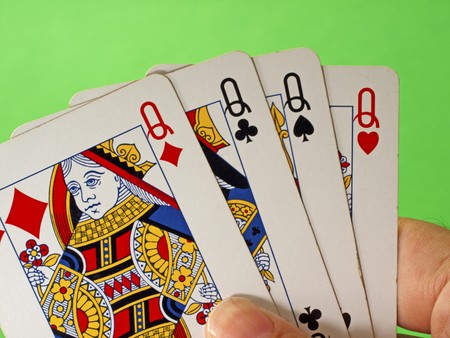 Four queens in male hand, green backgroundのeditorial素材