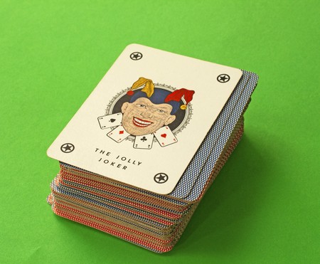 Joker on top of a bunch of playing cards, green backgroundのeditorial素材