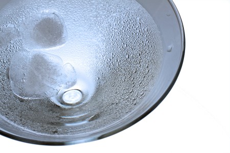 Strict close up of high part of a large glass with cubes of iceの写真素材