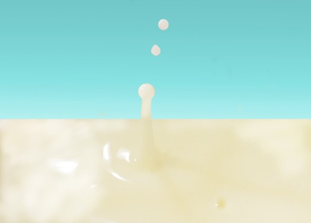 Closeup of a milk drop over light blue backgroundの写真素材