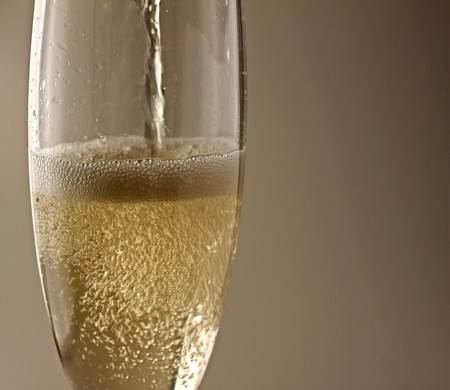 Flute with champagne over a light brown backgroundの写真素材