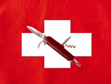 Swiss blade in the middle of a big swiss flagの写真素材