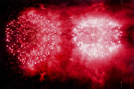 Red fireworks exploding over a completely black sky