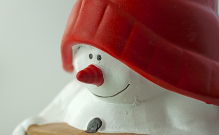 Closeup of face of a puppet of a Snowman with red hatの写真素材
