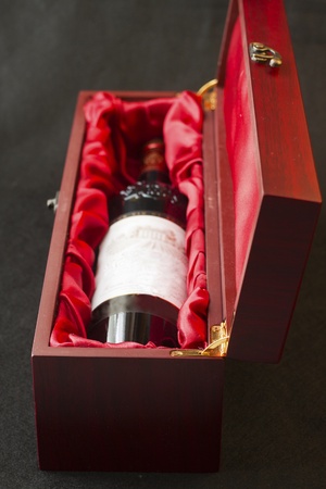 Bottle of red wine in a wooden boxの写真素材