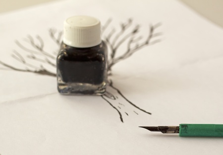 Pen for indian ink with little bottle over a drawingの写真素材