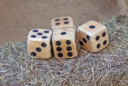 Big old wooden dice over a bale of hayの写真素材