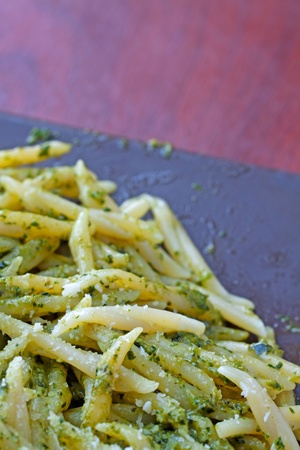 Close up of Trofie al pesto, typical Italian pasta, over brown plateの写真素材