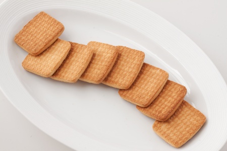 Long stack of biscuits over a white plateの写真素材