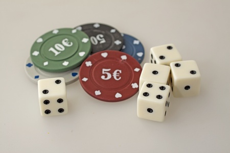 Four dice and some chips over gray backgroundの写真素材