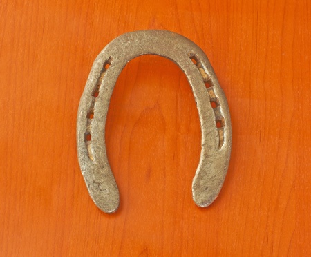 Entire view of an old horseshoe over wooden backgroundの写真素材