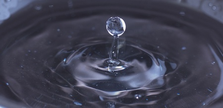 A single drop jumping out of dark waters