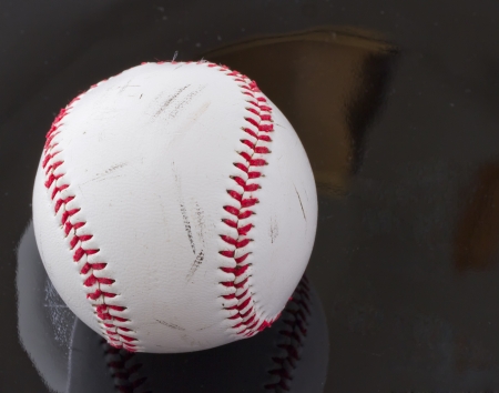Rugged baseball over a black reflecting surfaceの写真素材