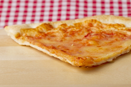 Close up of a slice of pizza over a wooden plateの写真素材