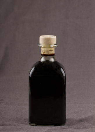 Elegant bottle of balsamic vinegar over brown backgroundの写真素材