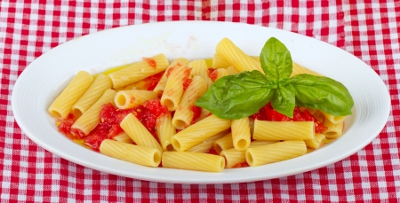 Typical Italian pasta maccheroni with raw tomatoesの写真素材