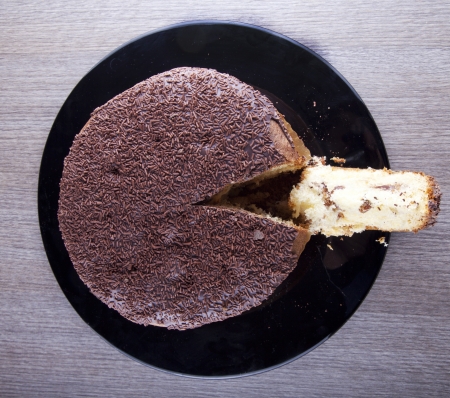 View from above of a chocolate cake with a cut sliceの写真素材