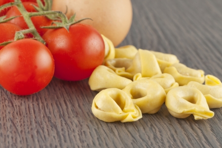Close up of Italian pasta "Agnolotti" near tomatoes and an eggの写真素材