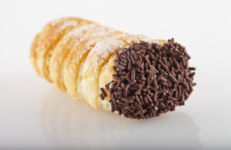 Close up of chocolate cannolo over white