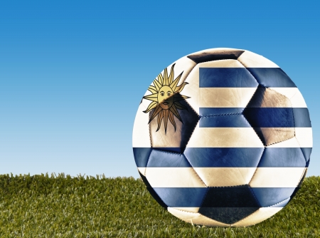 A football over grass decorated with Uruguay flagの写真素材