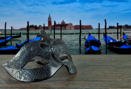 Black Venetian mask over a Venetian panorama with gondolas and San Marcoの写真素材