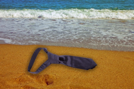 A black tie lying on the side of the beachの写真素材