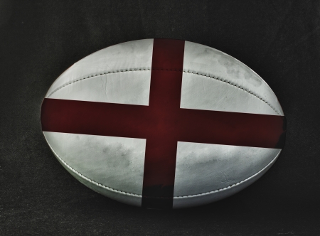 Rugby ball with England flag colors, over black backgroundの写真素材
