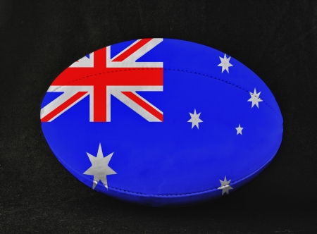 Rugby ball with Australia flag colors, over black backgroundの写真素材