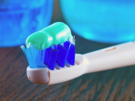 Electric toothbrush with toothpaste, and mouthwash on the backの写真素材