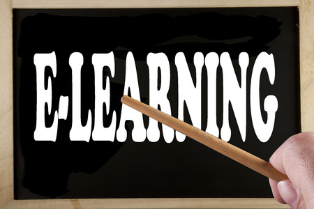 Blackboard with text "E-Learning", male hand and stickの写真素材